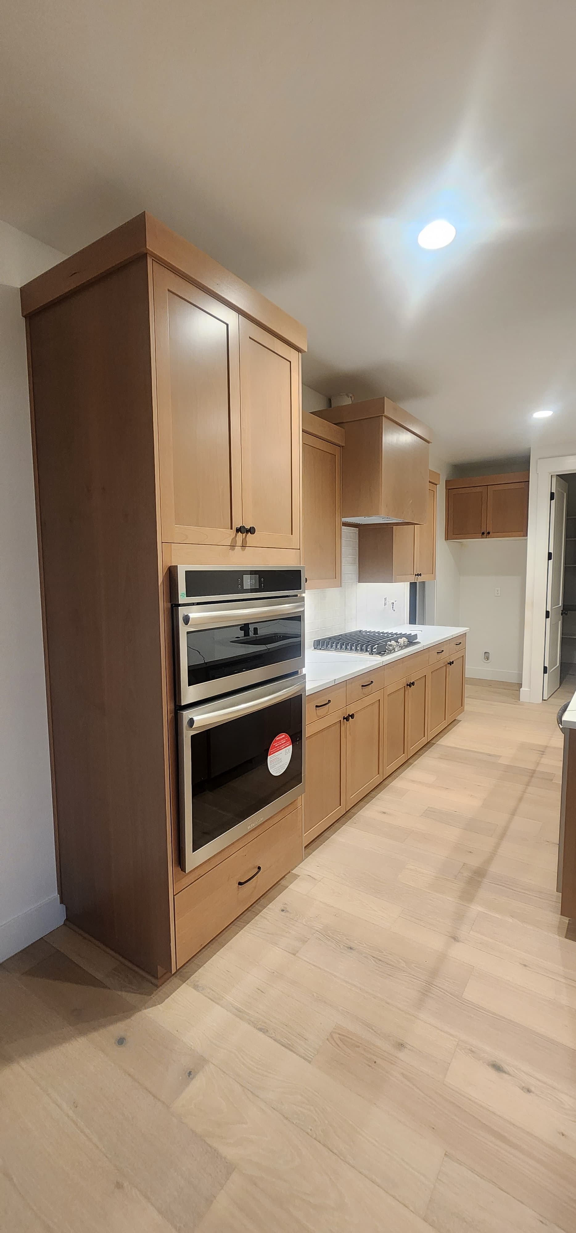 Dark walnut kitchen with double wall ovens and cooktop