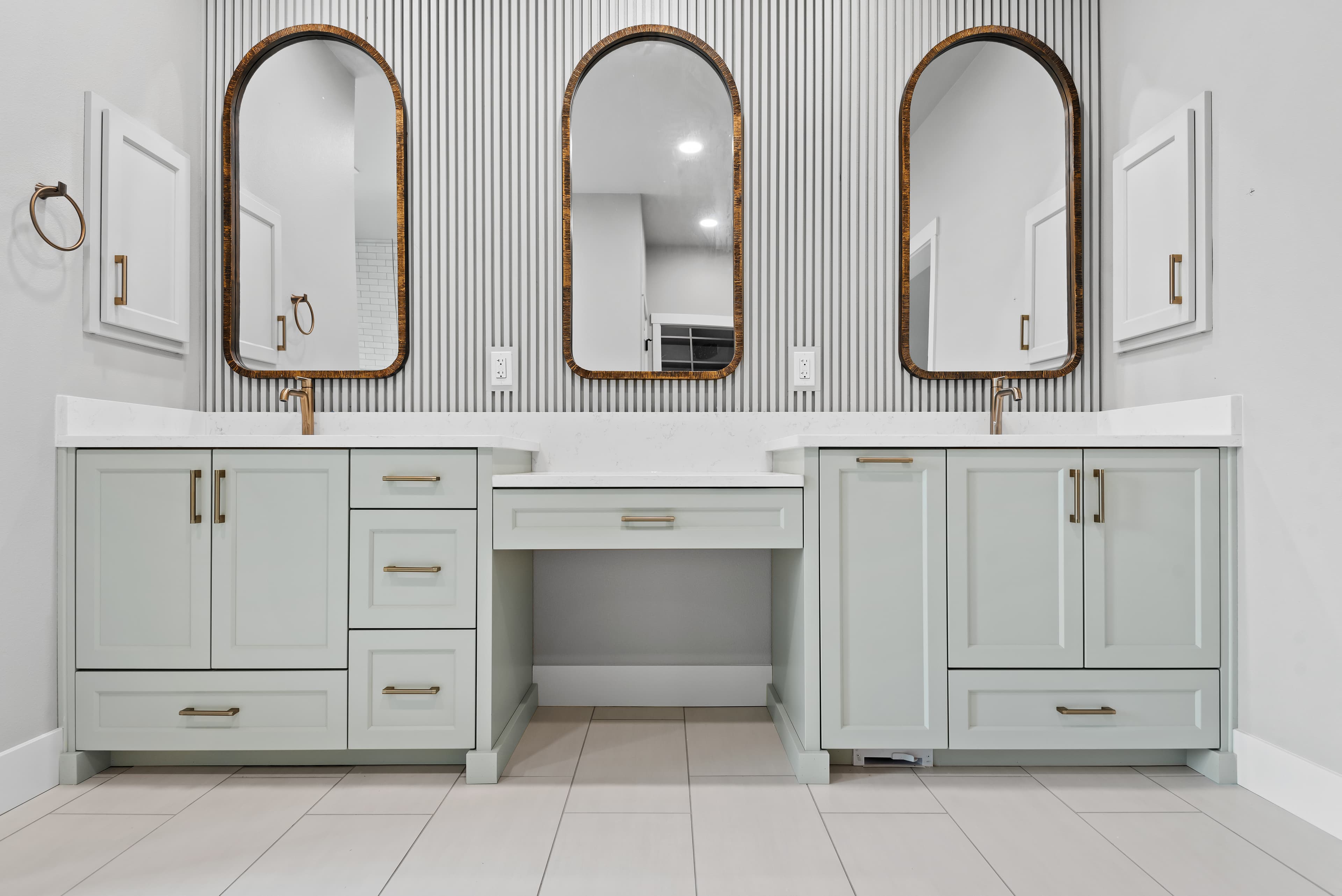Sage green vanity wall with three arched mirrors