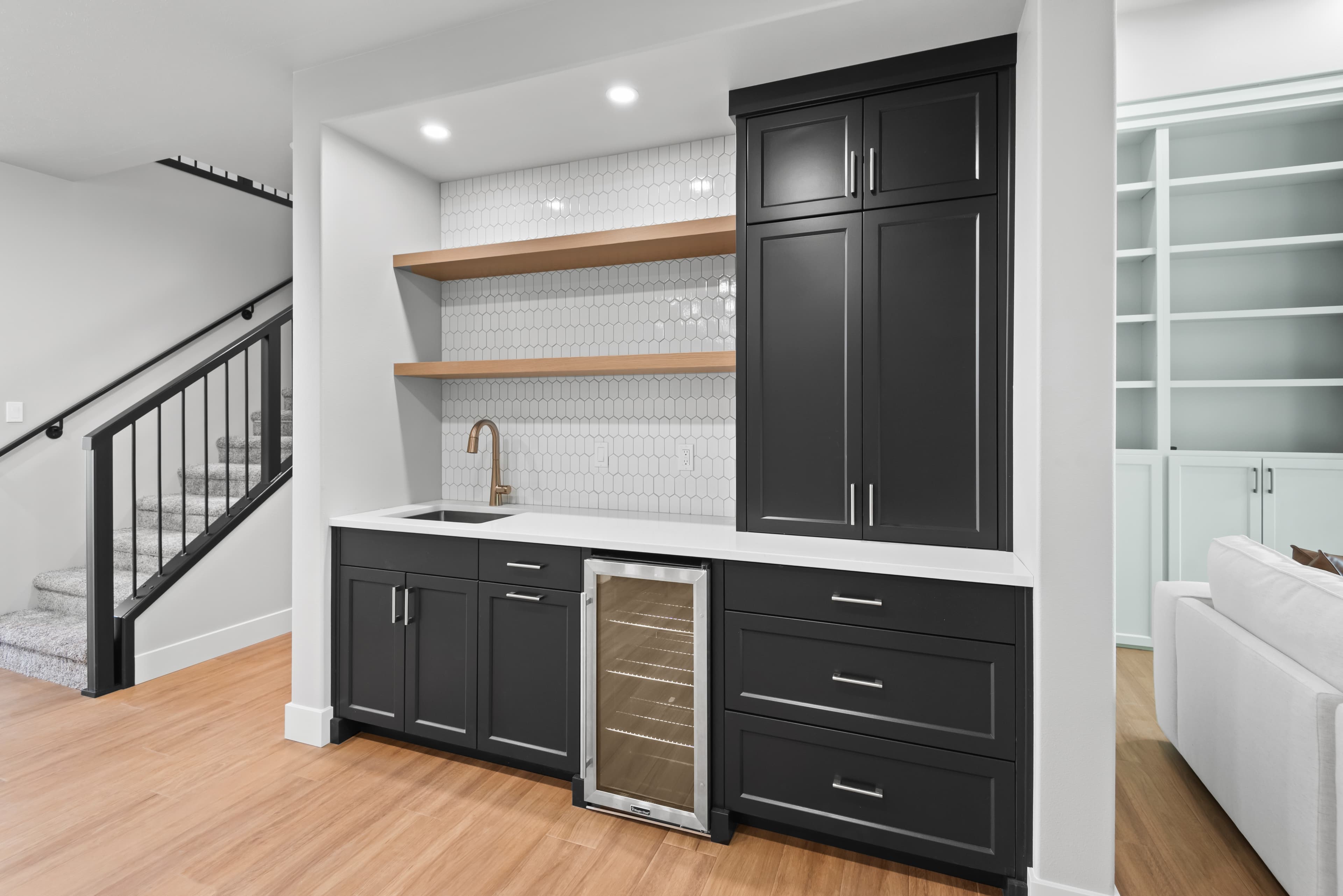 Black butler's pantry with wine fridge and open wood shelving